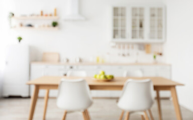 Wall Mural - Comfortable light kitchen and stylish cozy design. Blurred background with wooden dining table and chairs