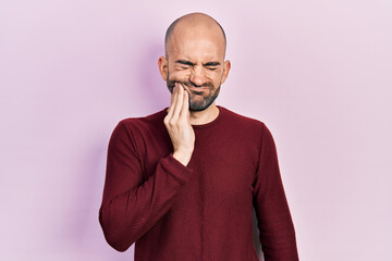 Sticker - Young bald man wearing casual clothes touching mouth with hand with painful expression because of toothache or dental illness on teeth. dentist