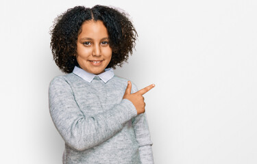 Wall Mural - Young little girl with afro hair wearing casual clothes cheerful with a smile of face pointing with hand and finger up to the side with happy and natural expression on face