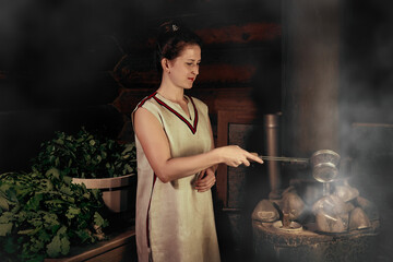 Wall Mural - woman in a bath pours water on hot stones on the stove