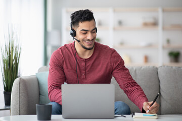 Wall Mural - Cheerful arab guy attending online training from home