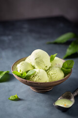 Wall Mural - Organic green mint ice cream in a bowl on dark background