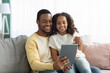 © Prostock-studio - Happy black dad and daughter using digital tablet together