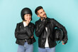 Couple with motorcycle helmet over isolated blue background thinking an idea while looking up