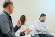 © Andrii - A young married couple of men and women talk to a psychologist at a therapy session. Psychology.