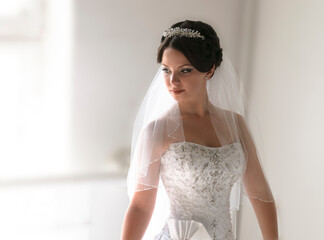 Wall Mural - The bride stands by the window during the day.