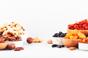 Wall Mural - Assortment of nuts and dried fruits. Healthy snacks. Dried apricots, figs, raisins, pecans, walnuts, hazelnuts, almonds and other. White background