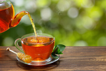 Wall Mural - tea with mint pouring from teapot into cup