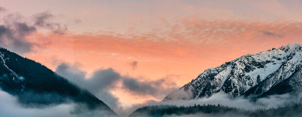 Wall Mural - Snow covered mountain peaks and colorful clouds over mountain range during sunset, Arkhyz villadge, Caucasus mountains, Russia