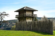 A reconstructed wooden Roman watchtower and a wooden border fence under a clear blue sky. This fortification was part of the 