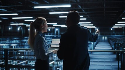 Fototapete - Data Center Male It Specialist and Female e-Business Fintech Startup Manager Talk, Use Laptop. Cloud Computing Server Farm with Two Information Technology Professionals working. Medium Wide Shot