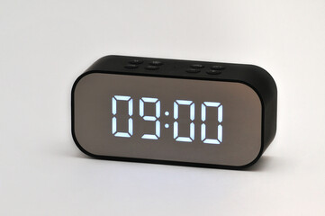 electronic clock with digital indication of time and date on a white background