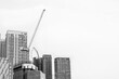 Black and white of Crane on the building under construction  on blue sky and cloud background