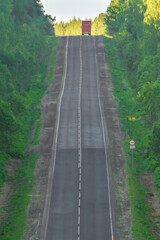 Wall Mural - a flat asphalt road with new markings runs through very hilly terrain