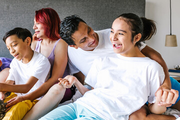 Wall Mural - young hispanic girl with cerebral palsy on bed with her father and family in Home in disability concept in Mexico city