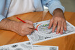 © New Africa - Man coloring antistress picture at table indoors, closeup
