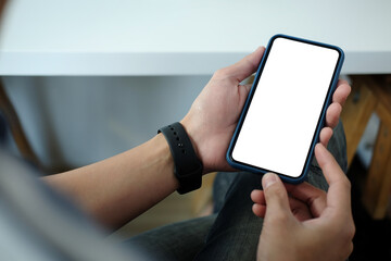 Close up view of businessman holding mock up smart phone with blank screen.	