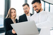 © Andrii  - Group of multiracial employees of software company consider a new startup in a laptop