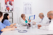 © DC Studio - Senior pediatrician woman discussing sickness treatment using clipboard for medical presentation explaining disease expertise. Physiotherapist doctor discussing with hospital team in meeting room