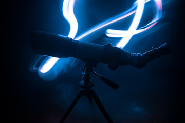 Wall Mural - silhouette of a astronomy telescope on dark foggy backlight.