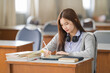 © EduLife Photos - Young desperate and stressful Asian woman student in student uniform doing examination assignment in a college university classroom alone