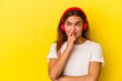 © Asier - Young caucasian woman listening to music isolated on yellow background relaxed thinking about something looking at a copy space.