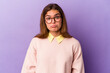 © Asier - Young caucasian woman isolated on purple background shrugs shoulders and open eyes confused.