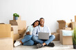 © Prostock-studio - Moving concept. Happy african american couple purchasing furniture for new apartment, sitting on floor and using laptop
