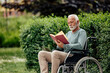 © bnenin - Disabled senior man, enjoying his book in the park.