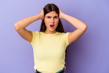 Wall Mural - Young caucasian woman isolated on purple background screaming with rage.