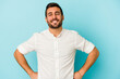 © Asier - Young caucasian man isolated on blue background confident keeping hands on hips.