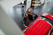 Top view of young couple choosing and trying new car in auto salon.