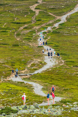 Wall Mural - people are walking on a trail up the mountain