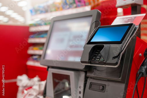 A POS machine at Woolworths Supermarket\'s self-serve checkout area with blur bokeh background