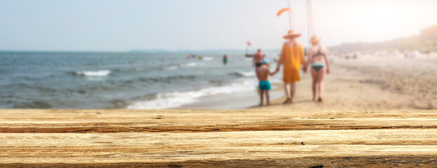 Wall Mural - A wooden table on a beautiful sunny holiday day with a charming sea landscape 