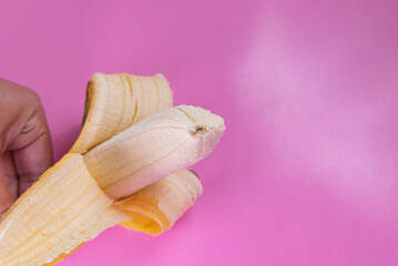 Wall Mural - Banana on the pink background - man holding