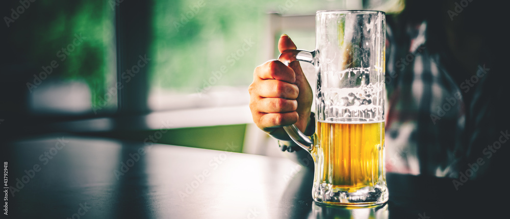 woman holds a glass of beer in his hand at the bar or pub - obrazy, fototapety, plakaty 