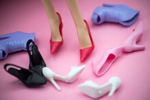 Closeup Of Feet Of Mannequin Doll With Her Shoes Collection On Pink Background