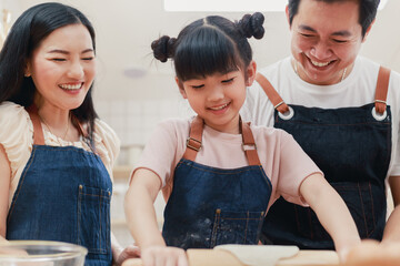 Adult Asian family are preparing the breakfast, in the kitchen with fun and full of joy. parent and daughter making bakery together at home