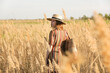 © triocean - Beautiful woman in striped dress and straw hat standing on meadow. Casual summer fashion, outdoor portrait with natural light.