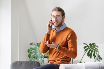 Canvas Print - Handsome young man talking by mobile phone in office