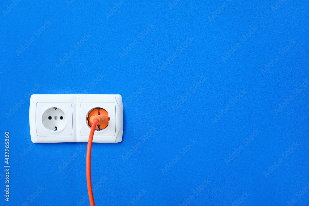 Electric socket with plug on color wall