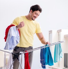 Wall Mural - Handsome man husband doing laundering at home