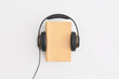 © LunaKate - Headphones and books on white background. Flat lay, top view. Concept of audiobook