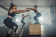© qunica.com - Group of athletic young fit girls in sportswear doing squats, having an intense legs workout