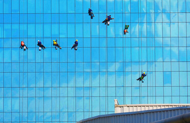 A team of high building glass cleaners hanging up in the sky 2