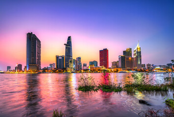 Riverside city sunset moments in the sky at end of day brighter coal sparkling skyscrapers along beautiful river in Ho Chi Minh City, Vietnam