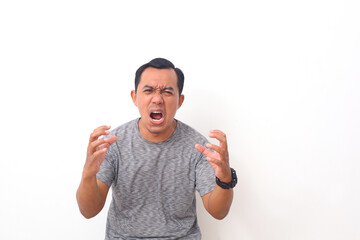 Asian man shouting frustrated with rage, hands trying to strangle, yelling mad. Isolated on white background with copyspace