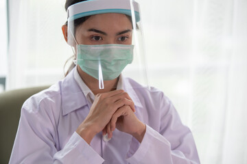 Young Asian female doctor wearing face shield for coronavirus or Covid-19 protection