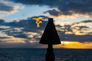 Sea view from tropical beach with sunny sky. Summer paradise beach of hawaii island. Tropical shore. Exotic summer beach with fire torches. Hawaiian icon, lights burning at dusk at beach.